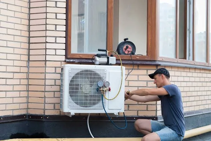 Stock photo of a technician installing a wall-mounted cooling unit