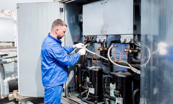 Stock photo of a technician inspecting large HVAC equipment